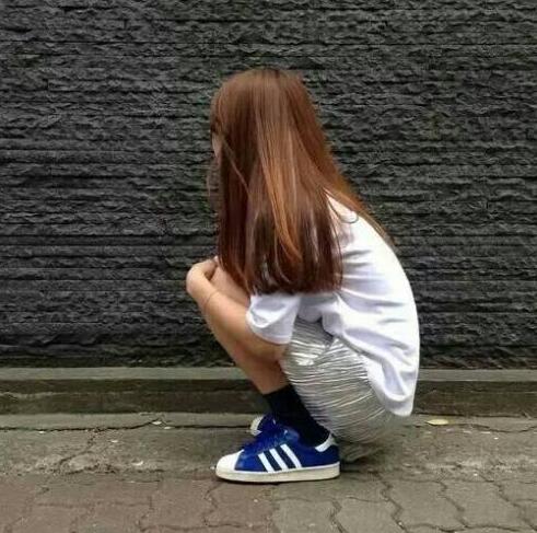 女生蹲在地上的背影照